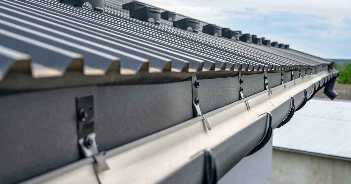 Close-up of a modern metal roof with a neatly installed gutter system and fasteners.